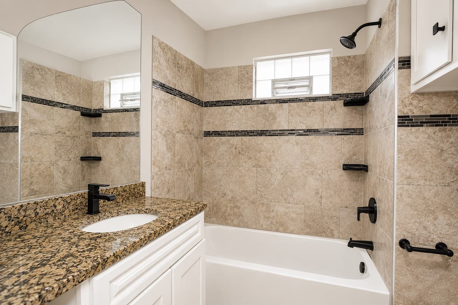 Completed bathroom remodel with tiled tub surround and updated vanity