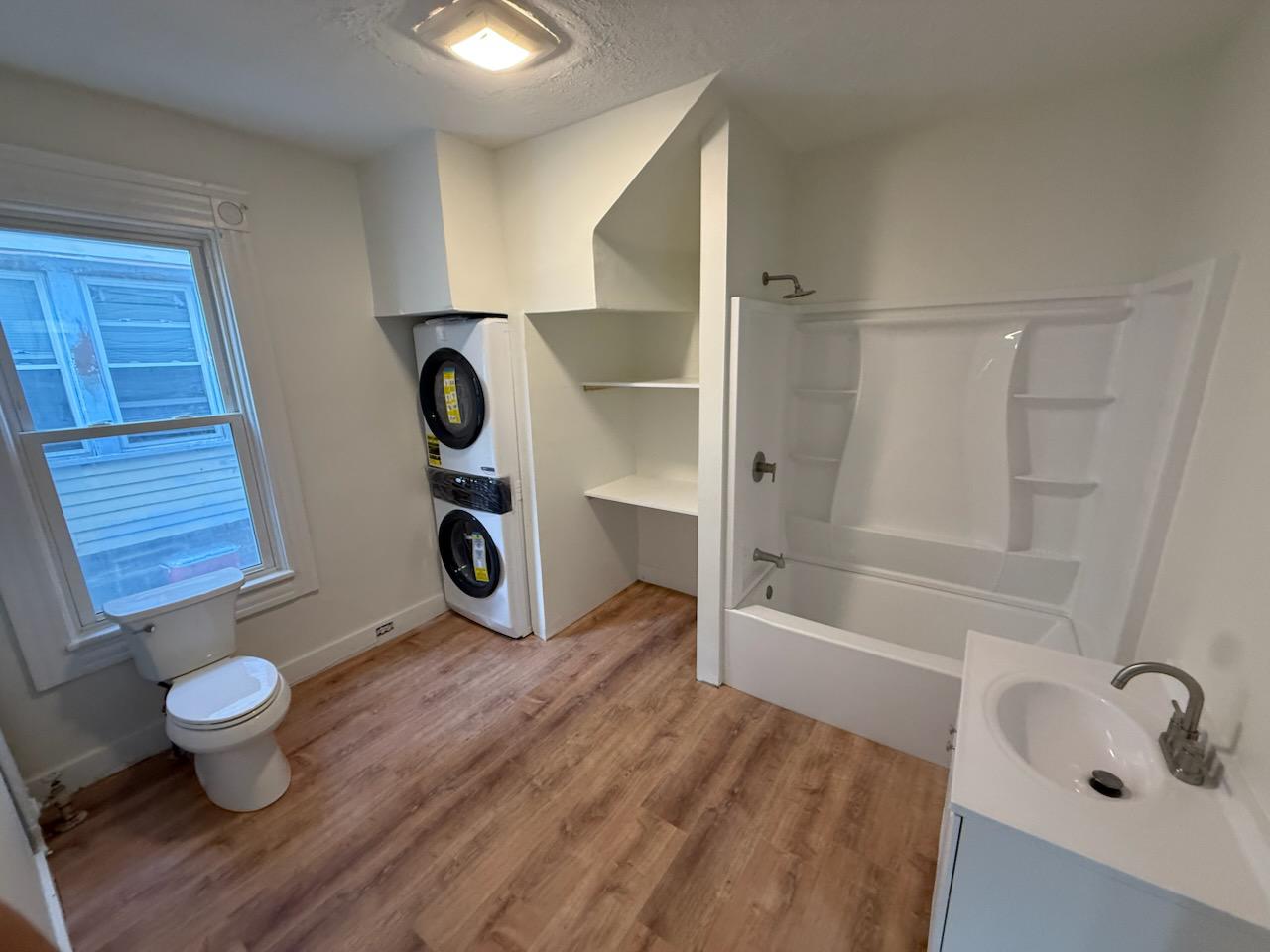 Finished bathroom and laundry room with built-in white storage