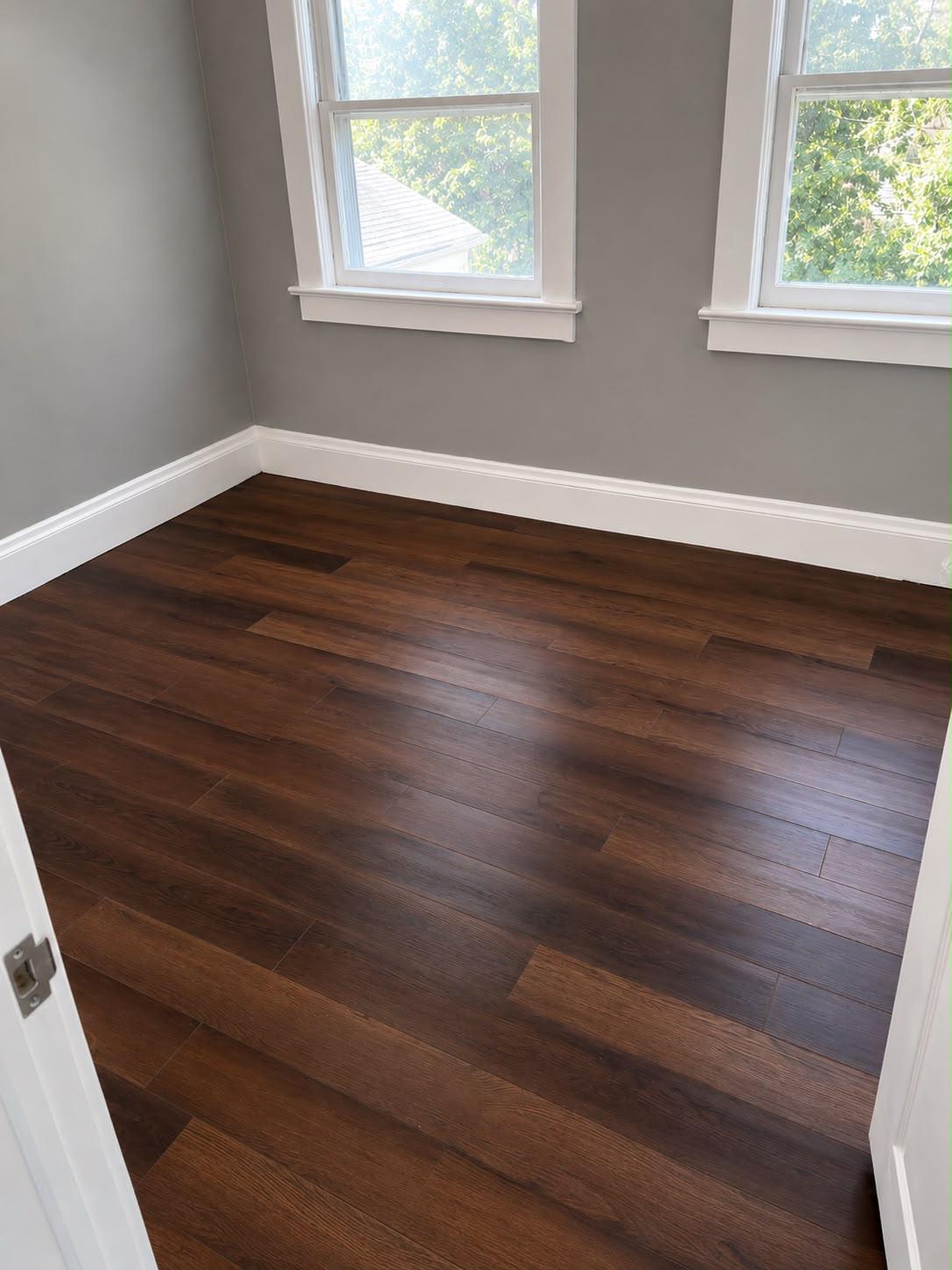 Small bedroom with dark hardwood flooring, gray walls and white trim