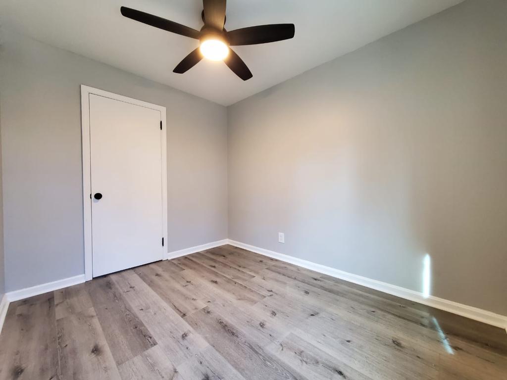 Bedroom detail with crisp white trim and wood-look plank flooring