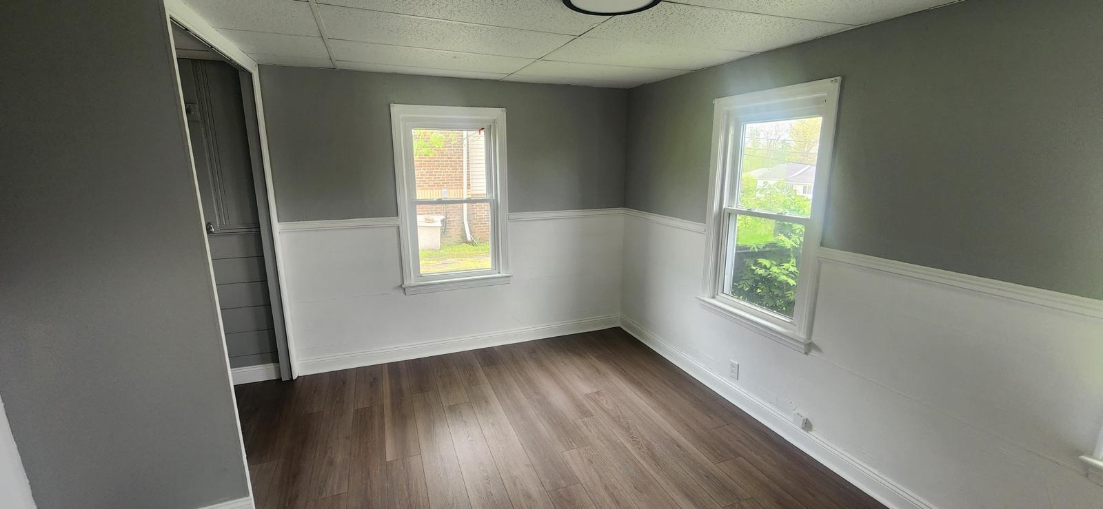 Gray dining room with white wainscoting and new plank flooring