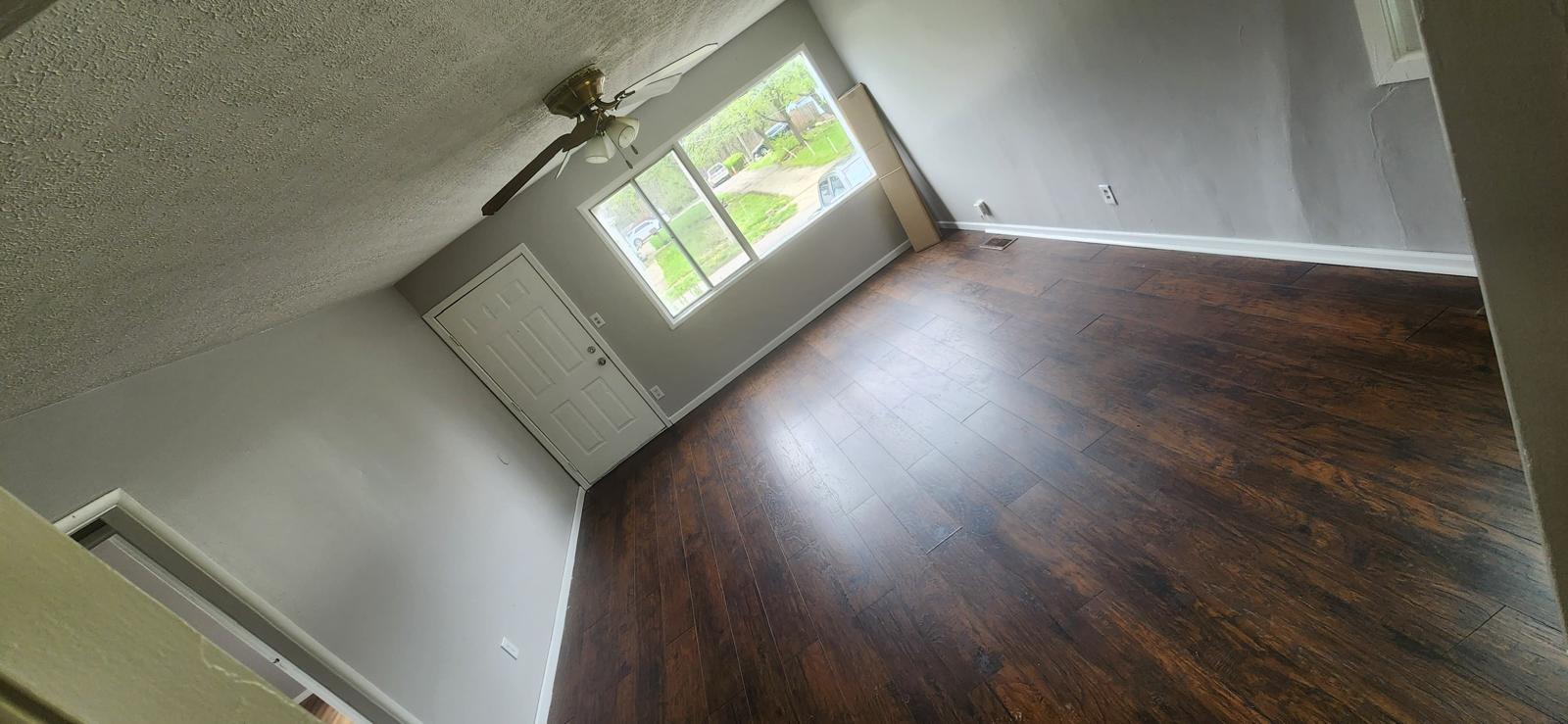 Freshly painted gray room with restored dark hardwood flooring
