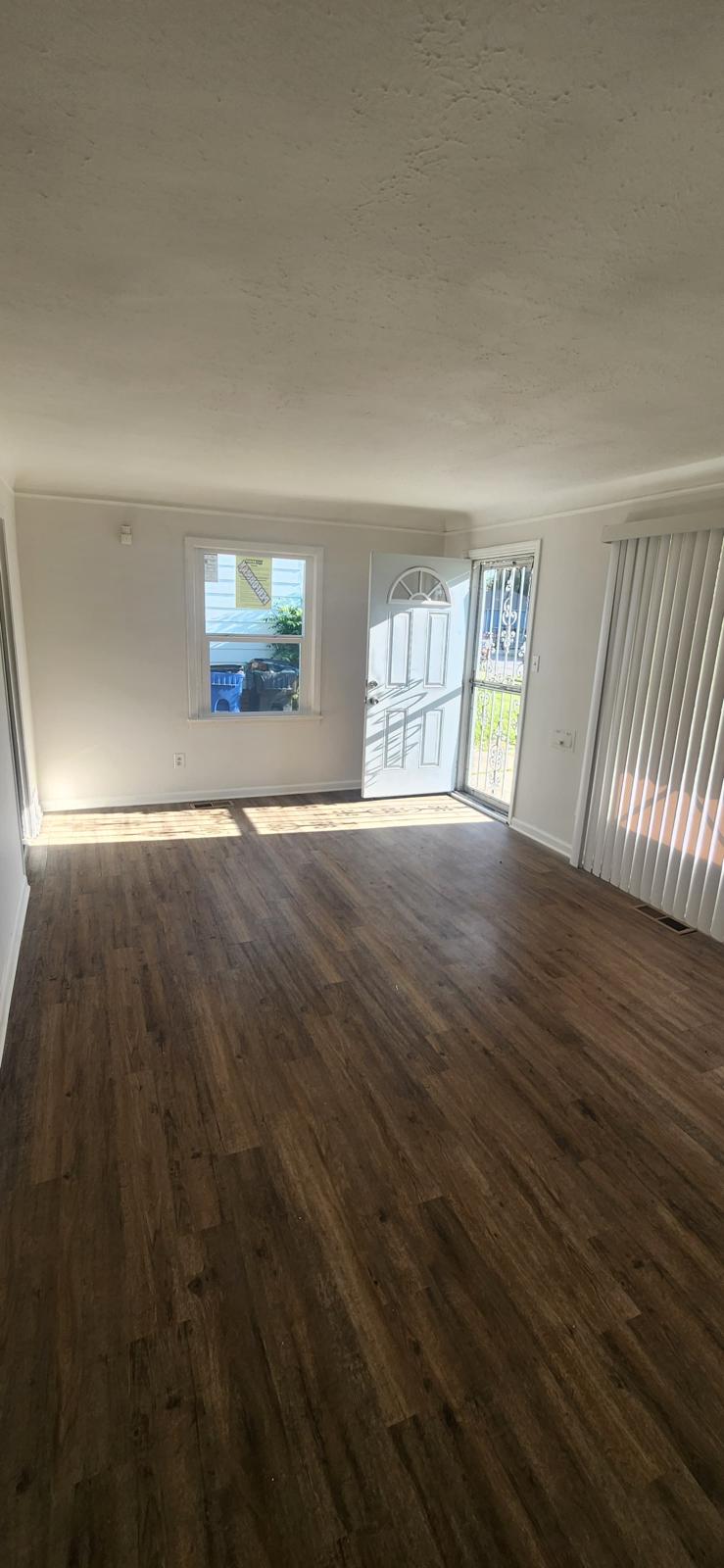 Renovated hallway with white doors and rich dark flooring