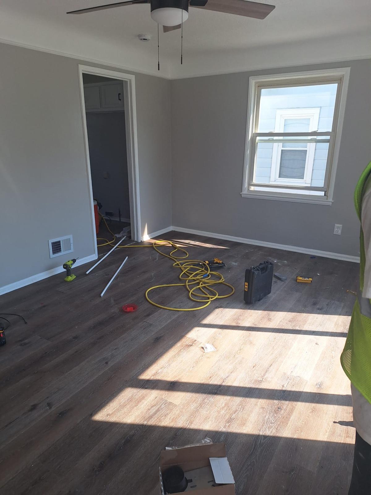 Bedroom flooring installation in progress beside freshly painted walls