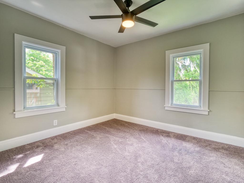 Finished bedroom with soft carpet, gray-green walls and white trim