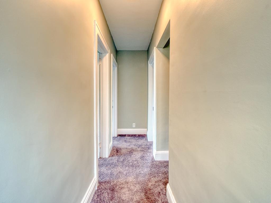 Upstairs hallway finished with neutral paint, white trim and carpet