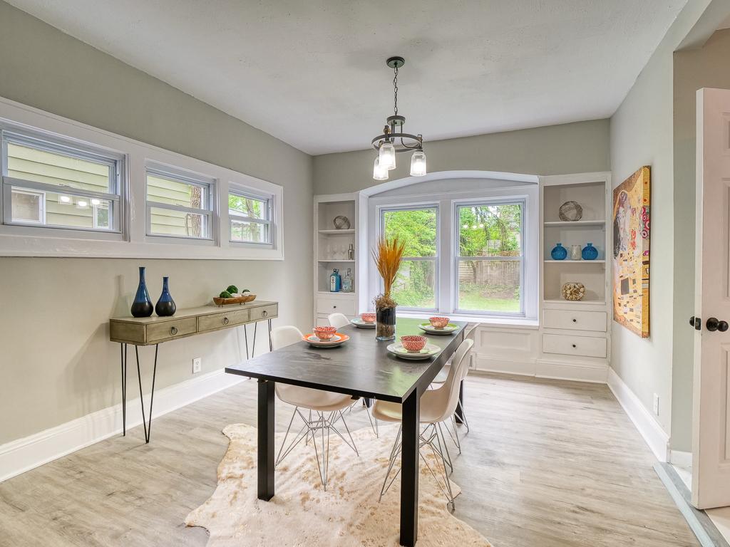 Bright dining room with wide windows, built-in shelving and new flooring