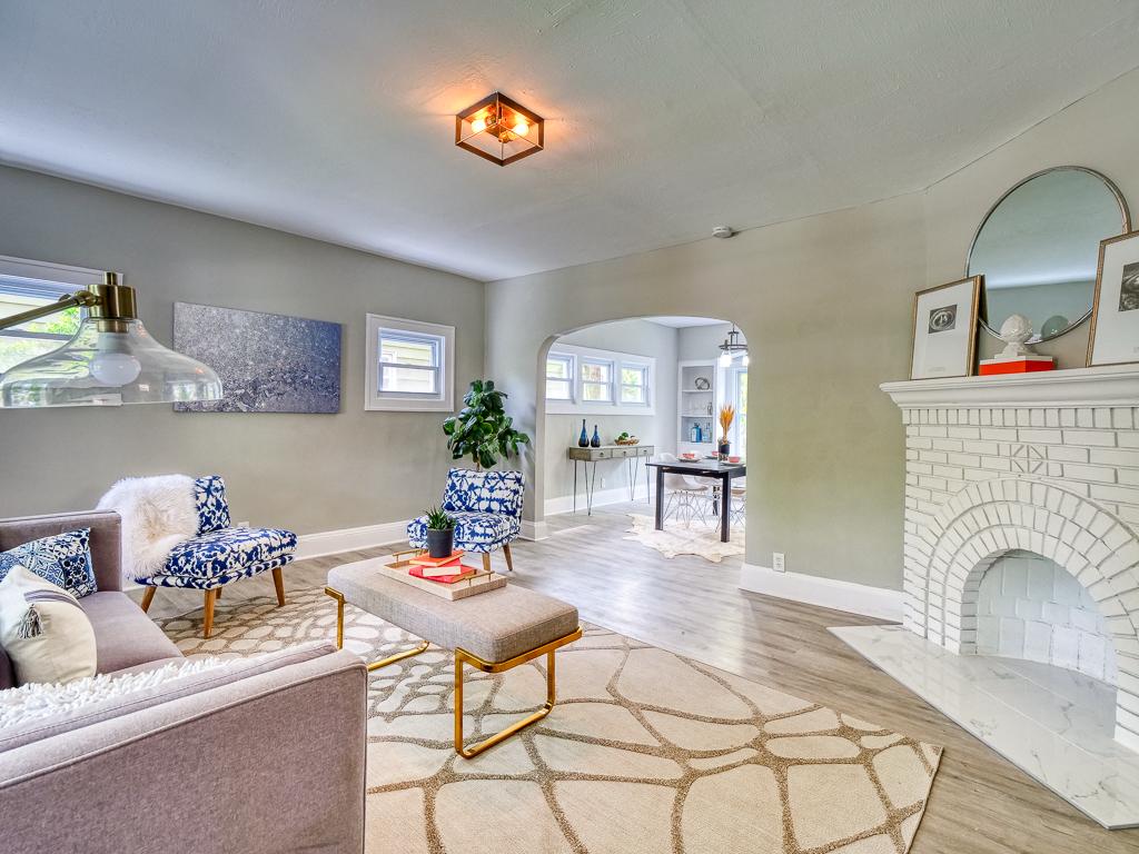 Remodeled living room with a white brick fireplace and adjoining dining space