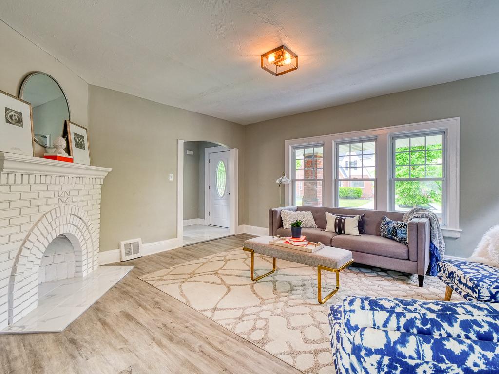Finished living room centered on a white brick fireplace