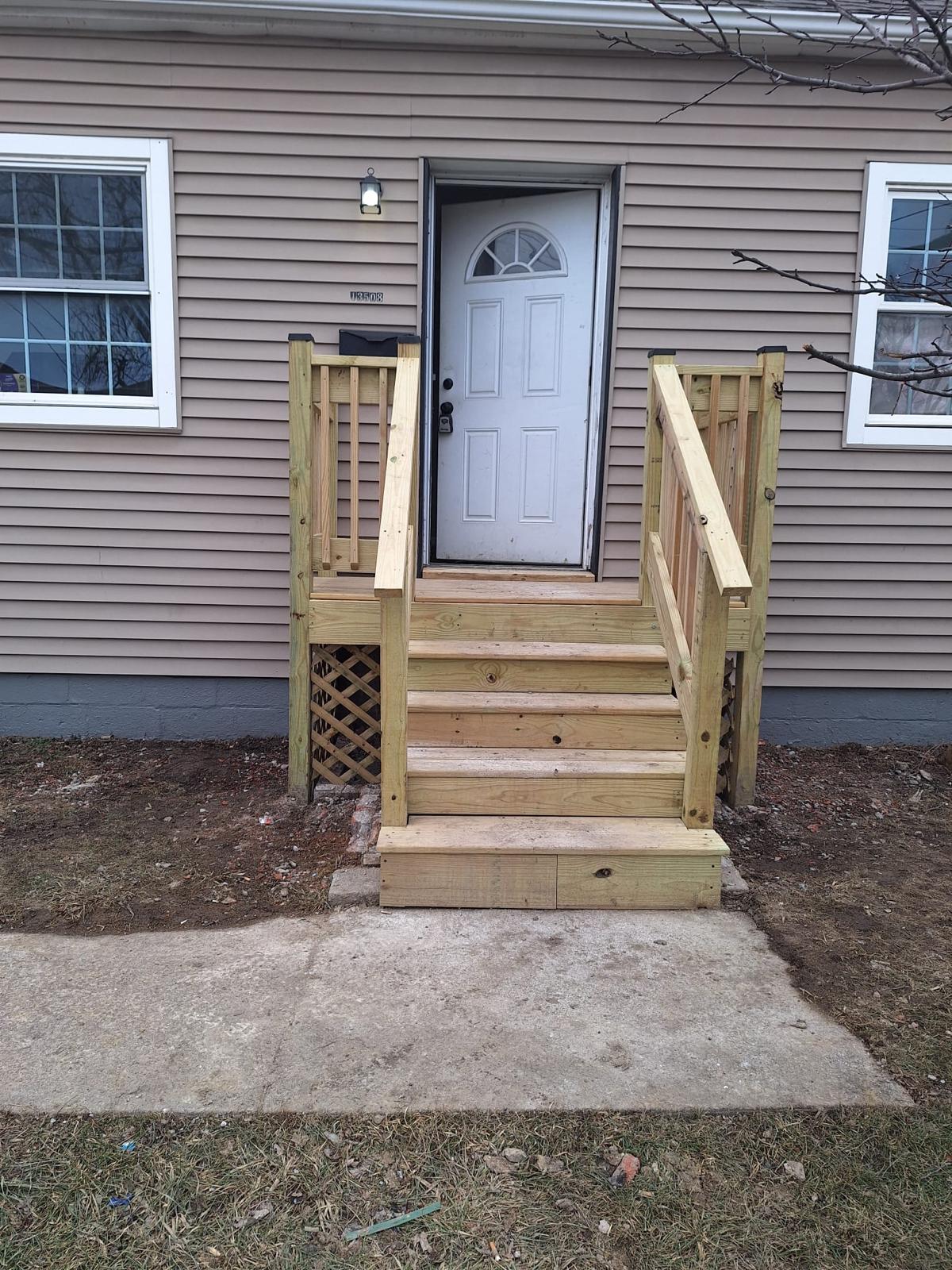 New wood steps and railings installed at a front entrance