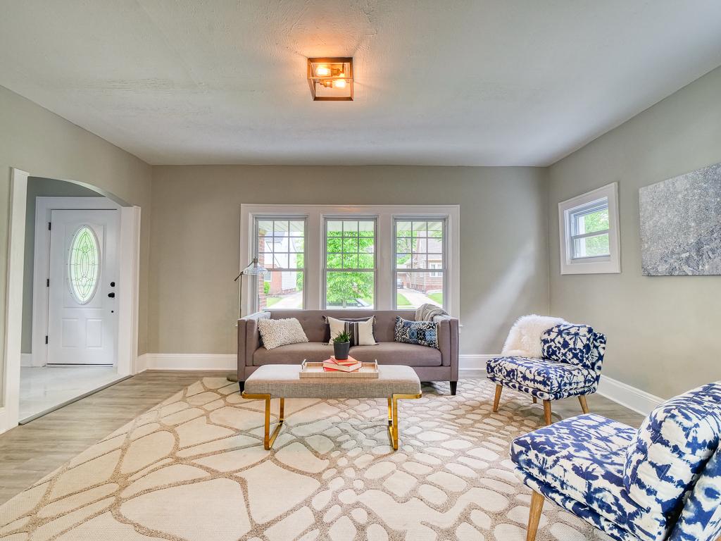 Open living room with neutral walls, bright windows and new flooring