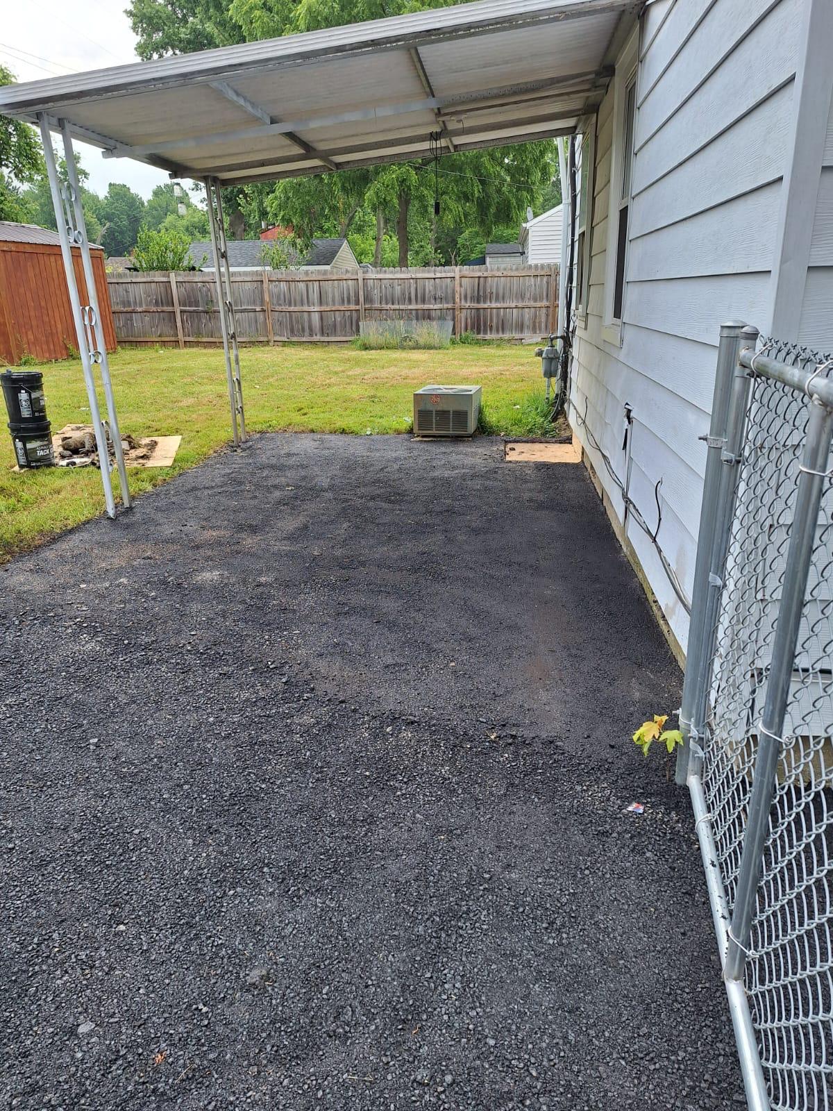 Newly resurfaced driveway leading toward a fenced backyard