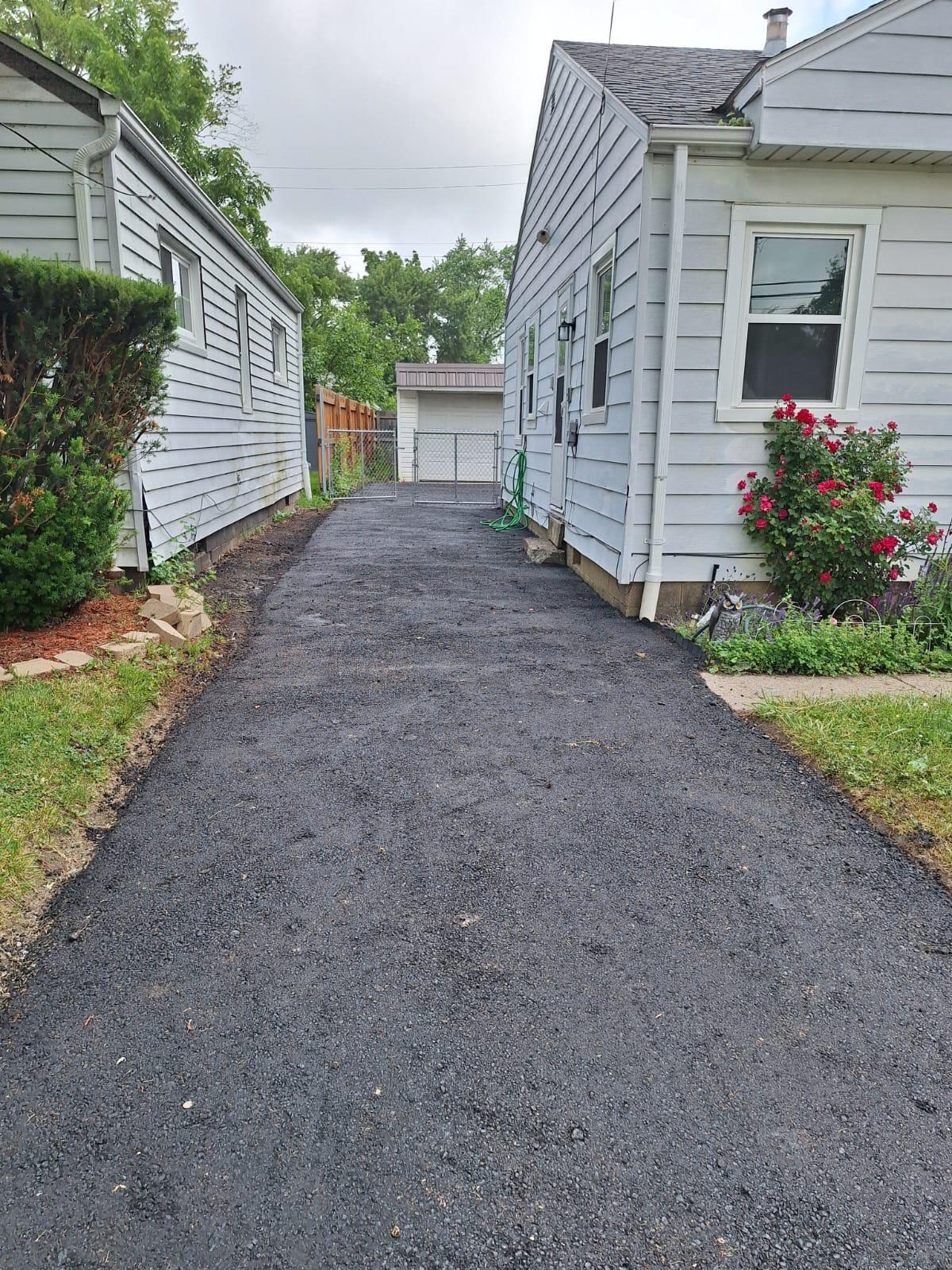 Freshly resurfaced driveway running beside a residential side yard