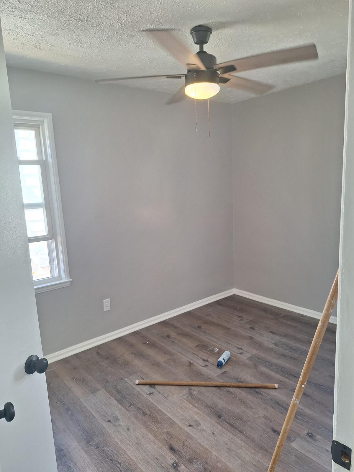 Wood-look flooring planks being installed in a bright room