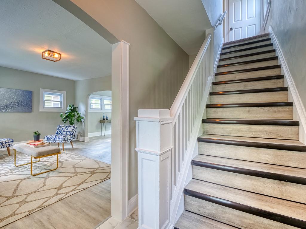 Finished living room and staircase with dark wood treads and a white railing